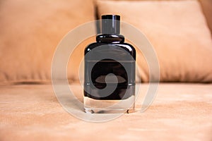 Male toilet water in a black bottle on a brown sofa