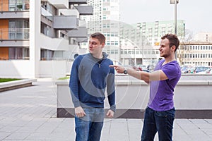 Male tourist asks for directions from man with mobile phone at c photo