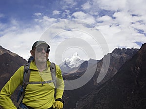 Male tourist with a backpack in the mountains. Himalayas, Nepal. In the background is AMA Dablam, one of the most beautiful peaks