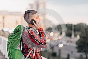 Male tourist with backpack talking by phone