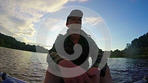 Male tourist having rest after paddling boat. Action cam, slowmo