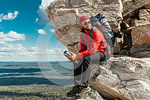 A male tourist is resting after a hard climb up the mountain. A traveler among the Rocky Mountains. A man is a traveler