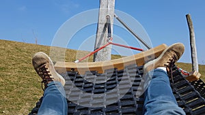 Male tourist swinging in hammock, lazy free time, refreshment on peaceful meadow