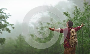 Male tourist on top of mountain in fog in autumn