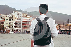 Male tourist walking  in the Canary Islands, Tenerife. Male traveler on the background of the city and mountains.