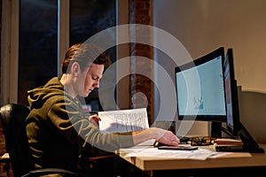 Male trader reading educational book at work