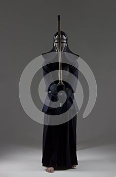 Male in tradition kendo armor with bamboo sword .