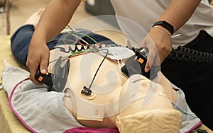 A male trainee performing defibrillation with a model on ACLS tr