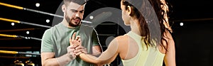 A male trainer demonstrates self-defense