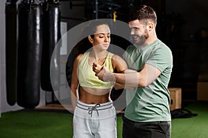 A male trainer demonstrates self-defense
