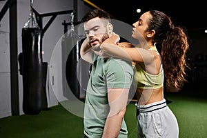 A male trainer demonstrates self-defense