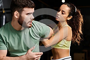 A male trainer demonstrates self-defense