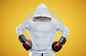 Male trainer posing in the studio with boxing gloves. White hoodie. Mixed martial arts concept