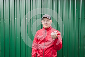 Male trainer in red suit holding small dumbbells