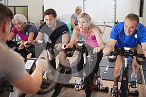 Male Trainer Taking Spin Class In Gym