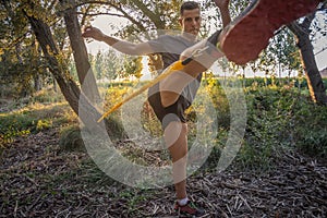 Male training with a resistance band kick