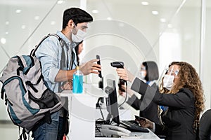 Male traveler give passport to female officer at airline check in counter for issue airplane ticket boarding pass. Woman staff wea