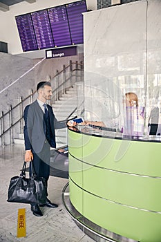 Male traveler giving his documents to airport crew