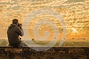 Male traveler photographing temples at Bagan Myanmar Asia at sunrise