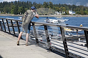 Young man backpack taking pictures ocean