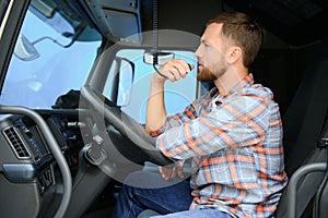 Male truck driver talking by CB radio system in his vehicle