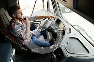 Male truck driver talking by CB radio system in his vehicle