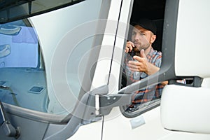 Male truck driver talking by CB radio system in his vehicle