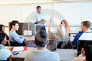 Male Tutor Teaching University Students In Classroom