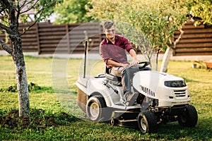 male using lawmower for landscaping works. Motorised agriculture concept