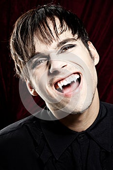 Male vampire smiling dangerously, showing fangs