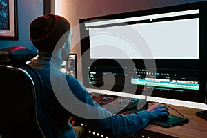 Male Video Editor Working on His Personal Computer with Big blank Display