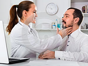 Male visitor consulting smiling woman doctor in hospital