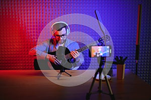 Male vlogger recording music related broadcast at studio