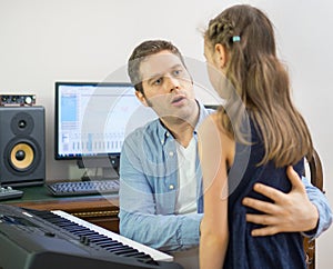 Male vocal coach teaching little girl how to sing.