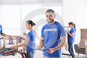 Male volunteer with clipboard listing donations