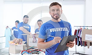 Male volunteer with clipboard listing donations