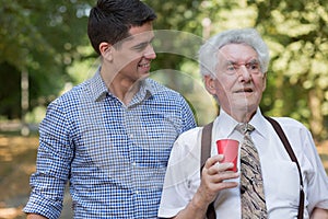 Samec dobrovolník podporující starý muž 