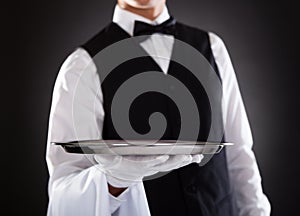 Male waiter holding tray