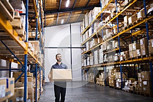 Male warehouse worker with a large box.