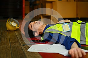 Male warehouse worker lying unconscious on floor after an accident. Safety, and Insurance concept