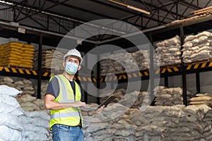 A male warehouse worker portrait with laptop in alum or chemical warehouse storage. International export business concept