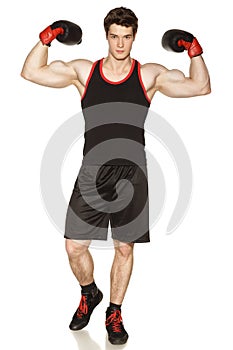 Male wearing boxing gloves showing his muscles