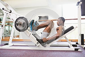 Male weightlifter doing leg presses in gym