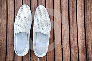 Male white shoes over the wooden table