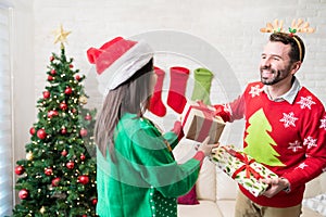 Male And Woman With Christmas Gifts At Home