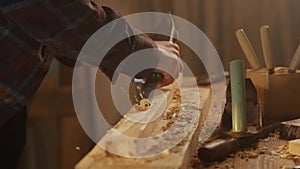 Male woodworker working in garage. Man professional carpenter specialist working with wooden materials in workshop