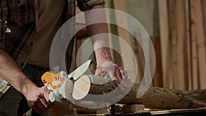 Male woodworker working in garage. Man professional carpenter working with wooden materials in workshop sawing wood