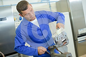 Male worker during appliance assembling work