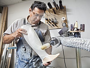 Male worker buffing prosthetic limb