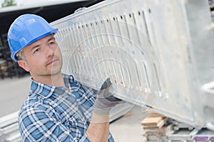 male worker carrying girder photo